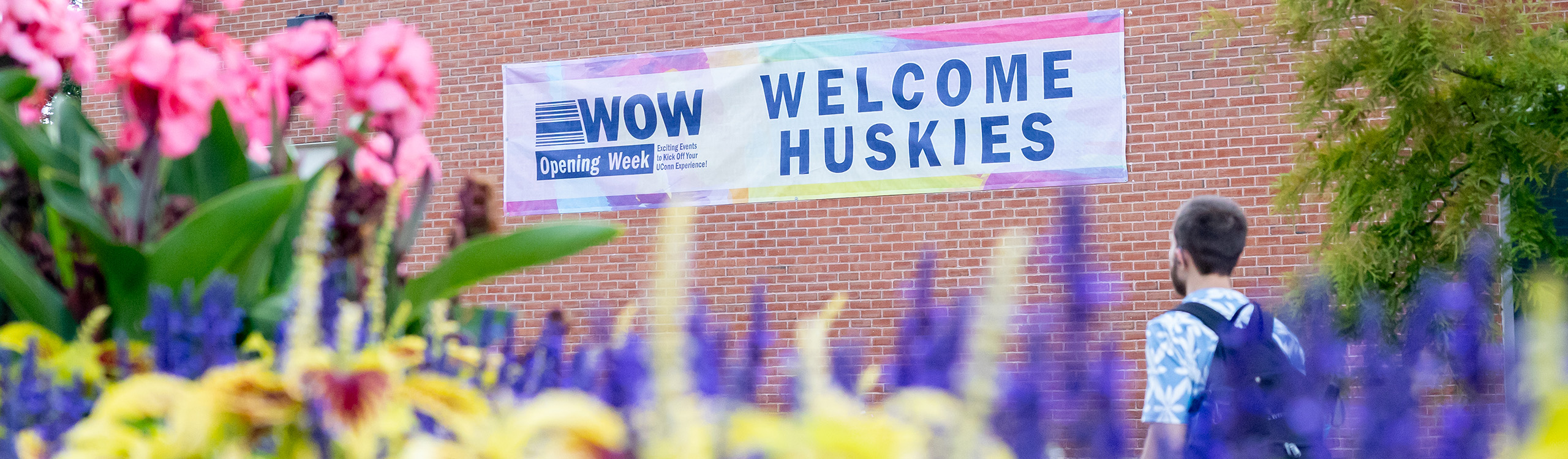 Welcome Huskies sign behind blooming flowers